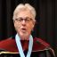 Dean Gary Bowen, wearing academic regalia, speaks at lecturn during Commencement 2021
