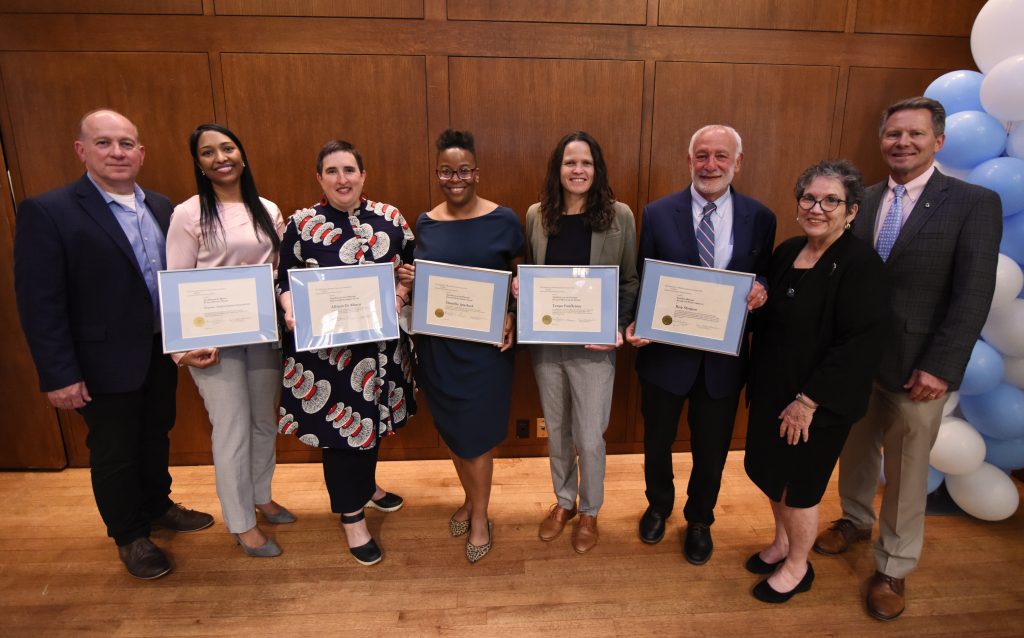 UNC faculty, staff, students and organizatioal reps pose with their framed certificates for the University public service award ceremony.