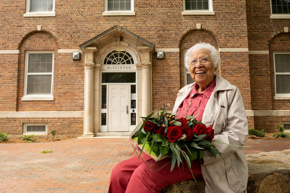 Hortense McClinton poses in front of UNC residence hall renamed in her honor.