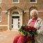 UNC Social Work Pioneer Hortense McClinton sits in front a residence hall on campus renamed in her honor.