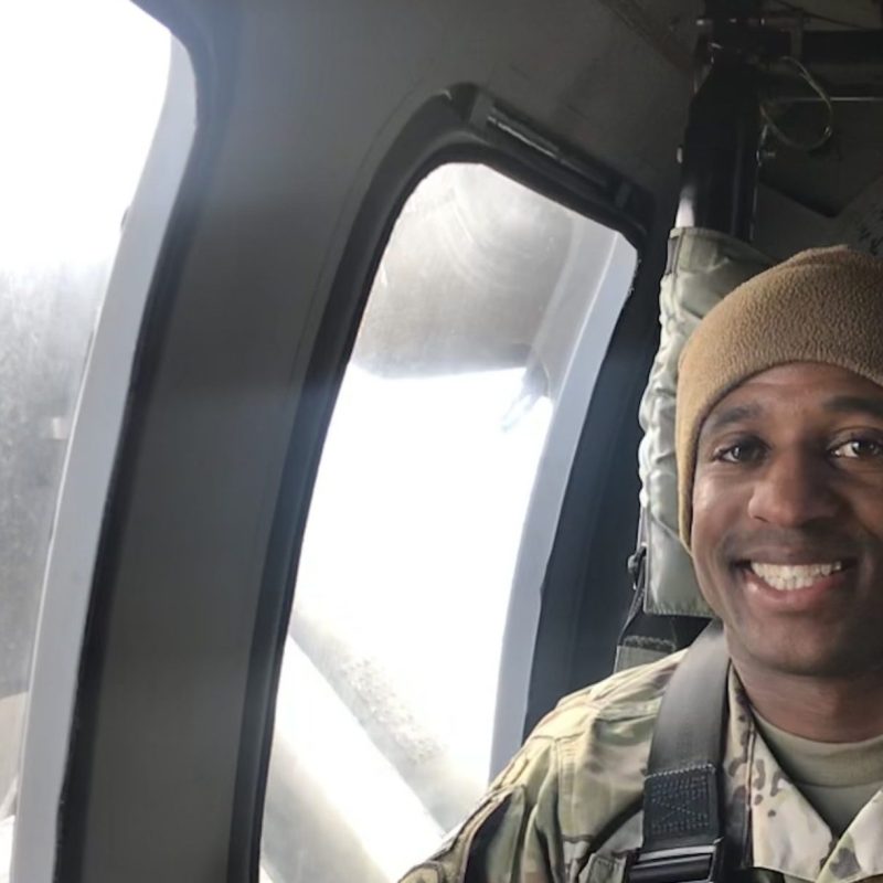 Capt. Kenneth Rodle Harris III, active-duty Army social work officer, gives a thumbs while riding aboard a military aircraft.