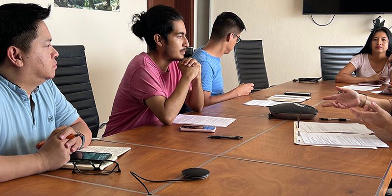 University of North Carolina researchers sit at a table with local community members in the Galapagos Islands to discuss their research project.